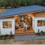 The Aspen container home exterior with wood deck and seating at dusk